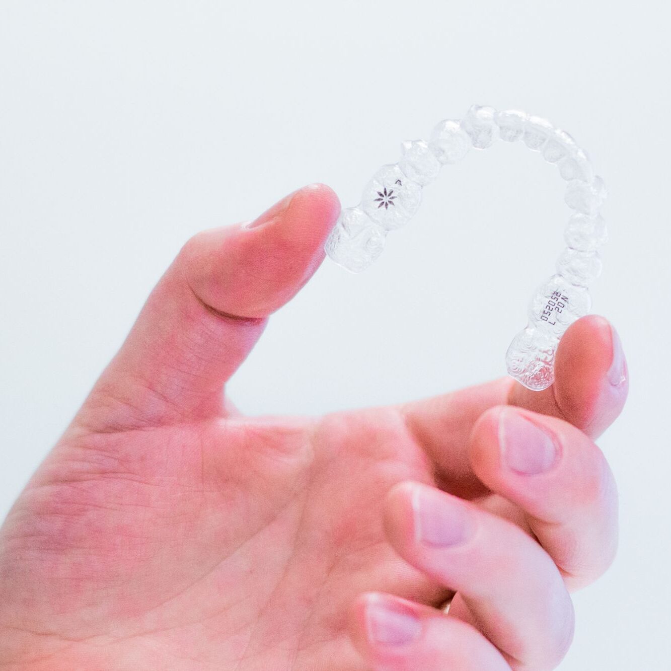 hand-holding-invisalign-aligners